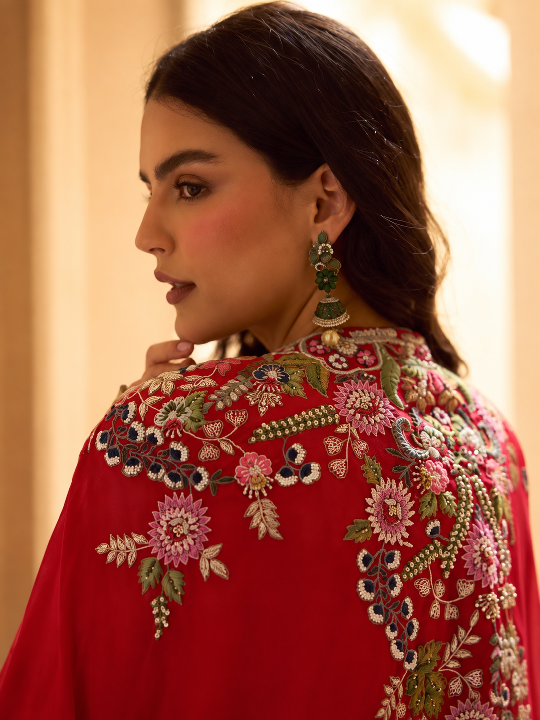Red embroidered cape-style lehenga set seated view