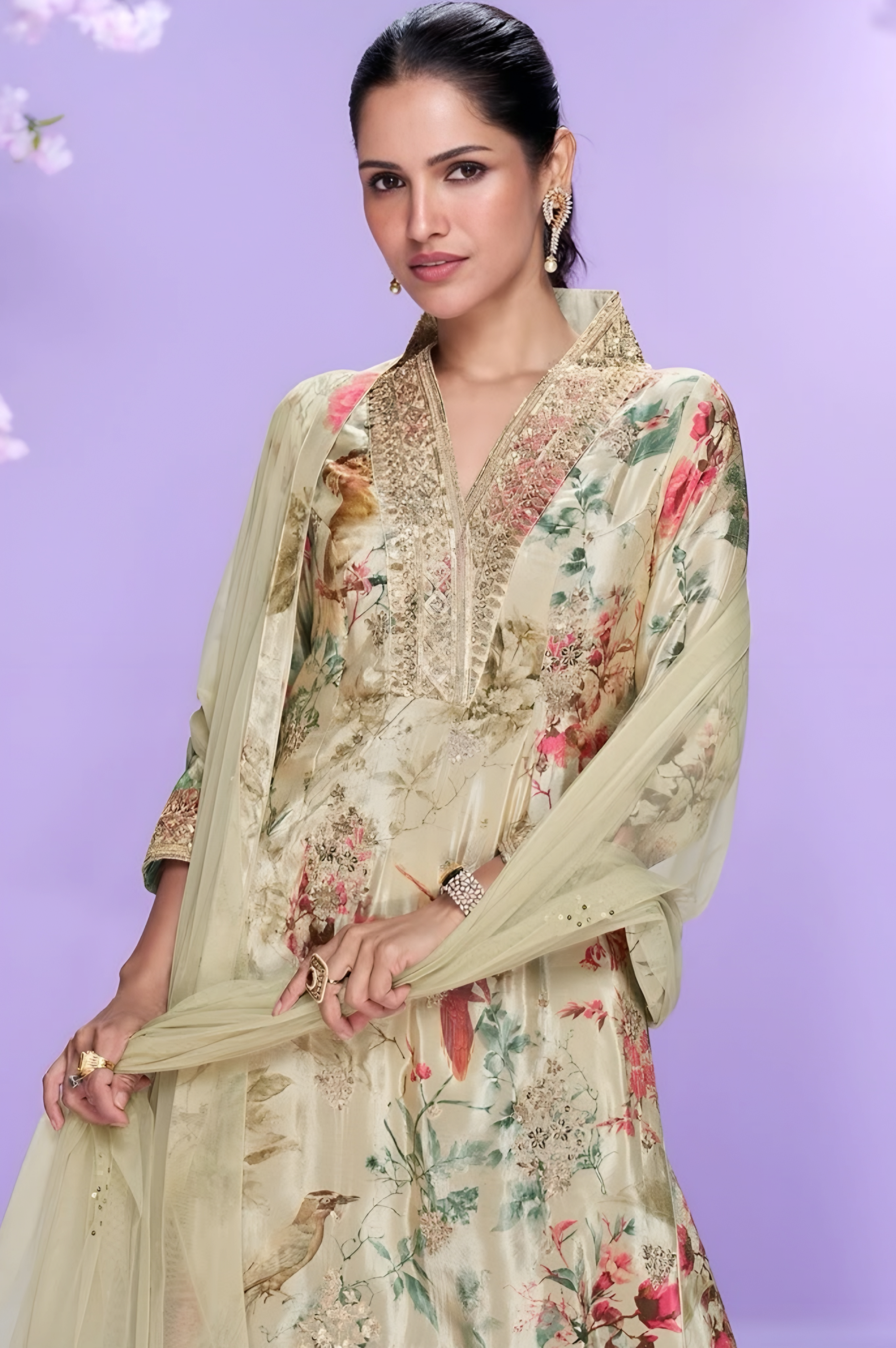 Woman wearing a floral dress with a matching dupatta against a light purple background