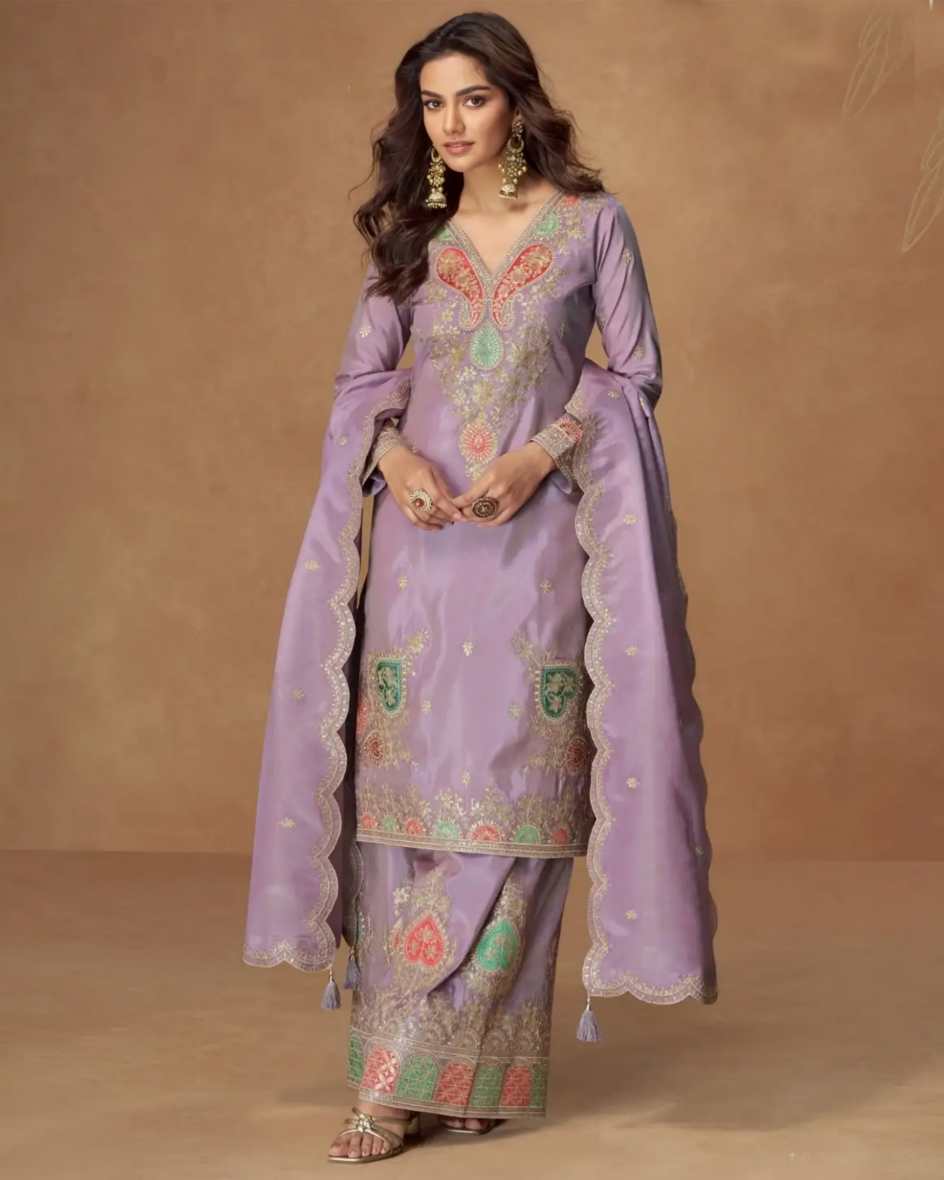 Woman wearing a lavender embroidered traditional outfit with a brown background