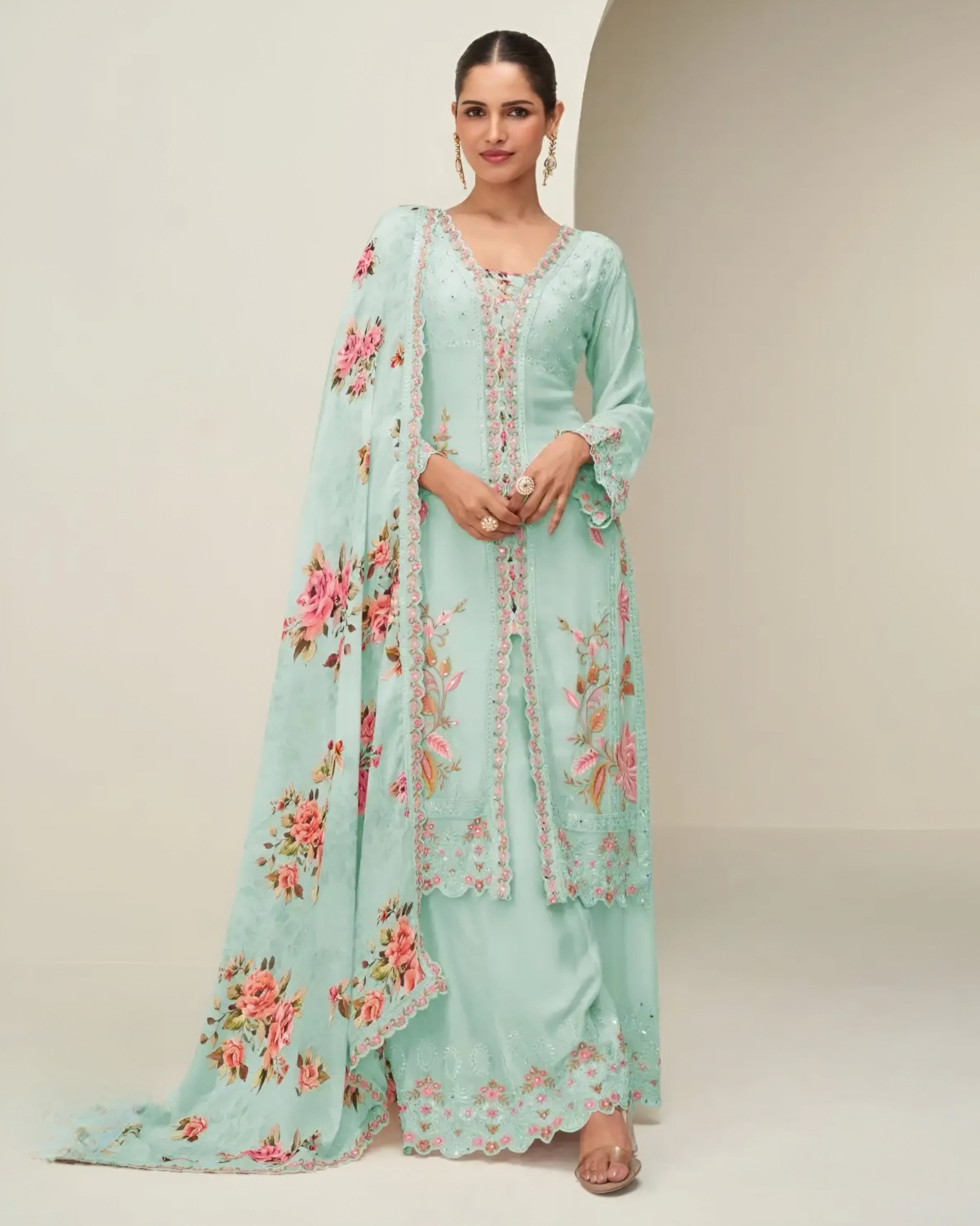 Woman wearing a light blue embroidered outfit with a matching dupatta on a plain background