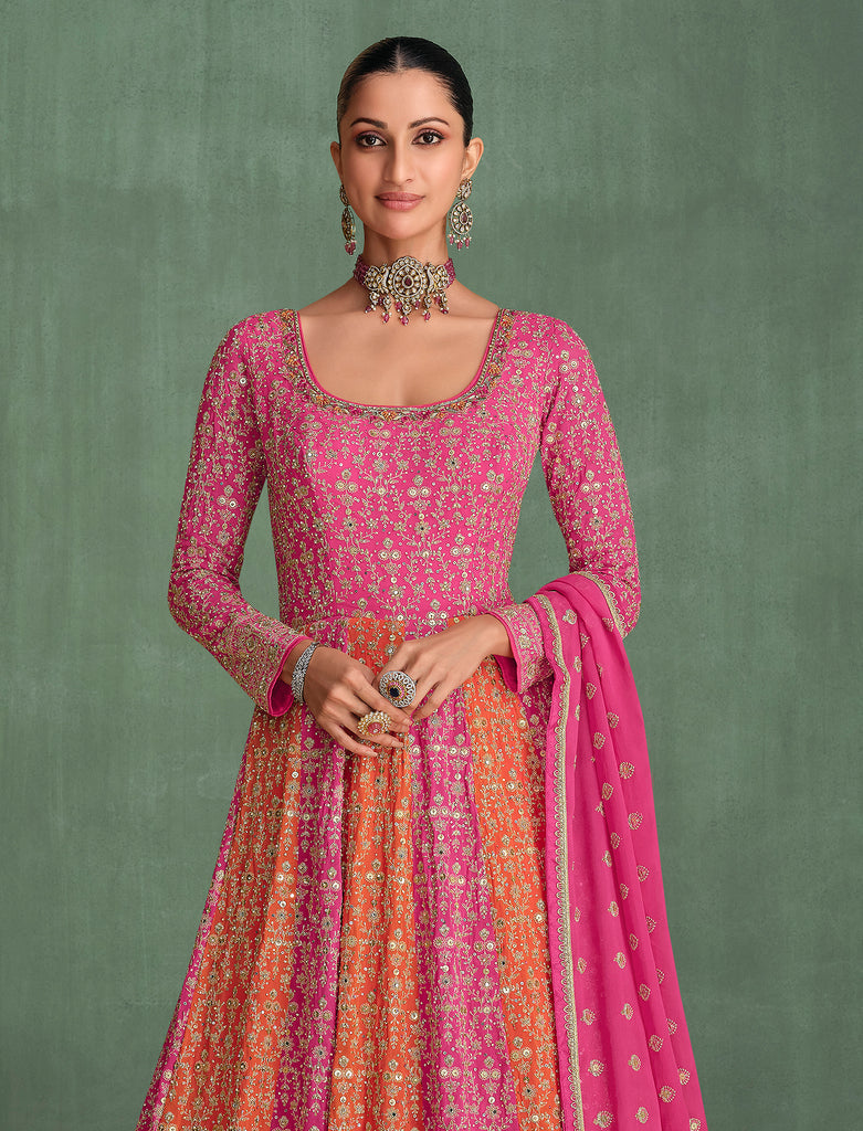 Woman wearing a pink and orange traditional outfit with a green background