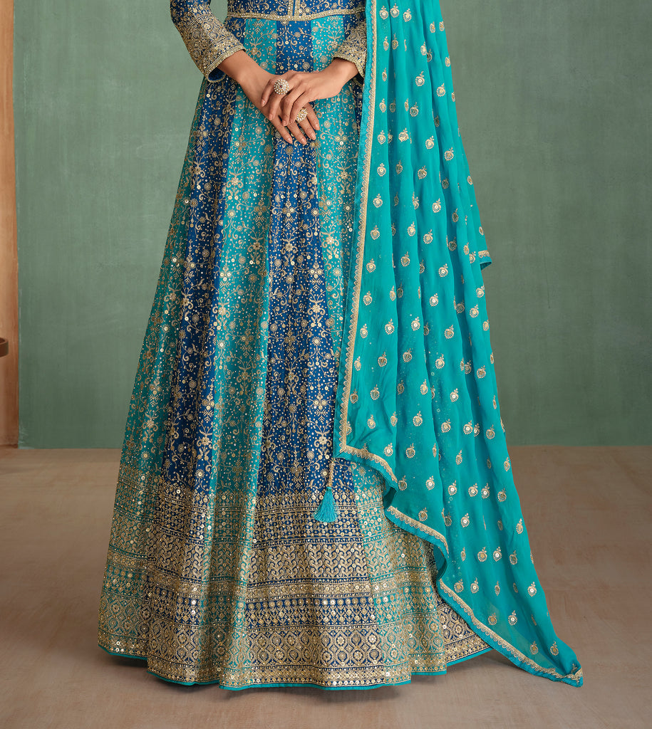 Traditional blue and green embroidered outfit with a matching dupatta on a neutral background