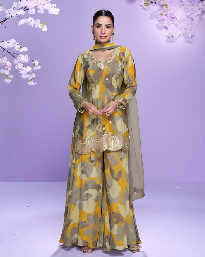 Woman wearing a floral salwar kameez with a purple background and cherry blossoms.