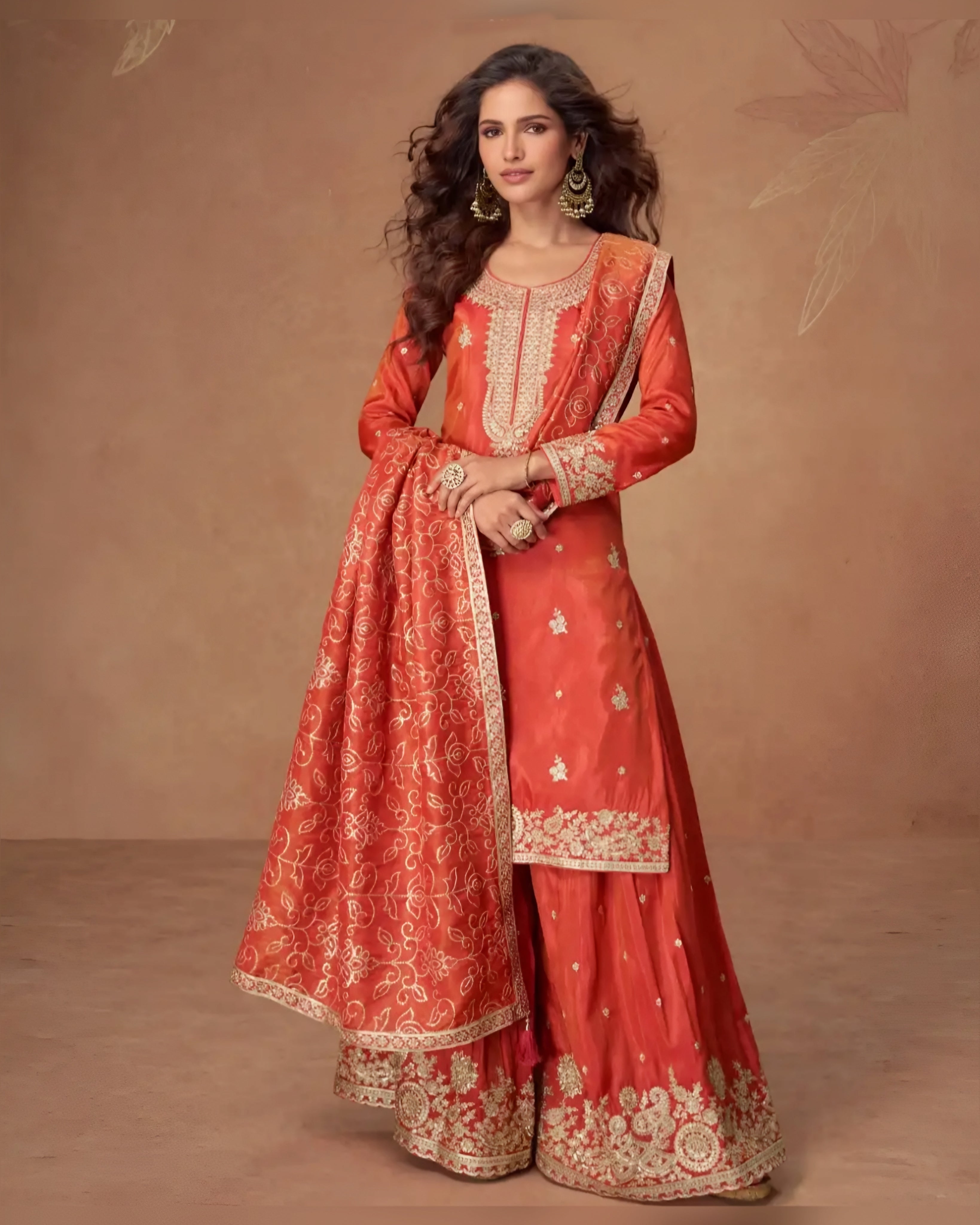 Woman wearing a traditional red and gold embroidered outfit against a brown background