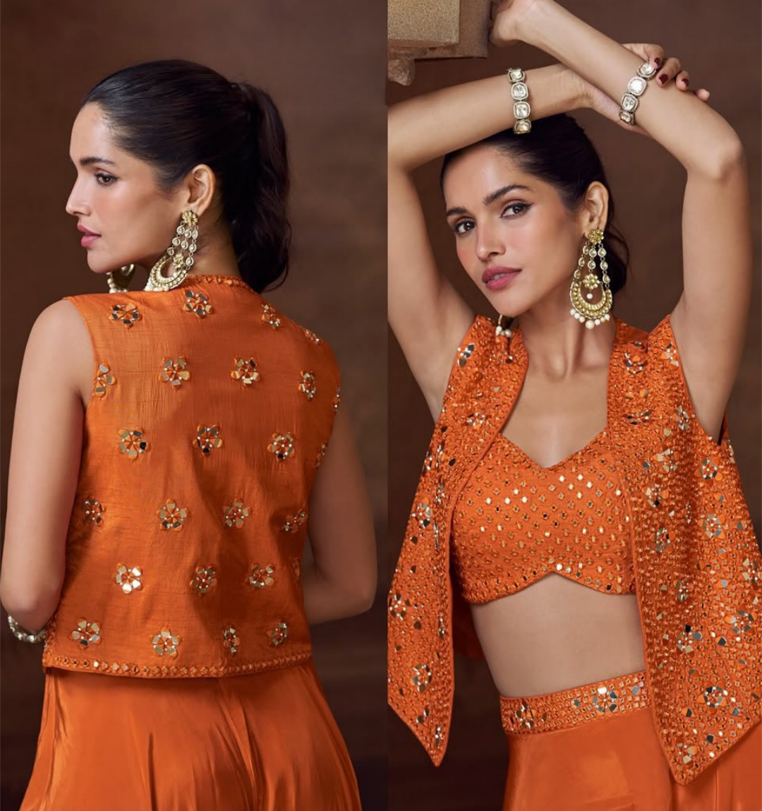 Woman wearing an orange traditional outfit with gold embellishments against a brown background