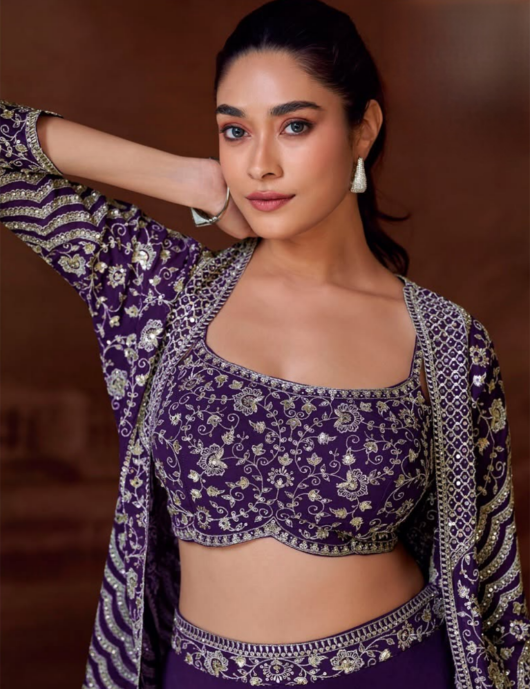 Woman wearing a purple embroidered traditional outfit with a blurred background