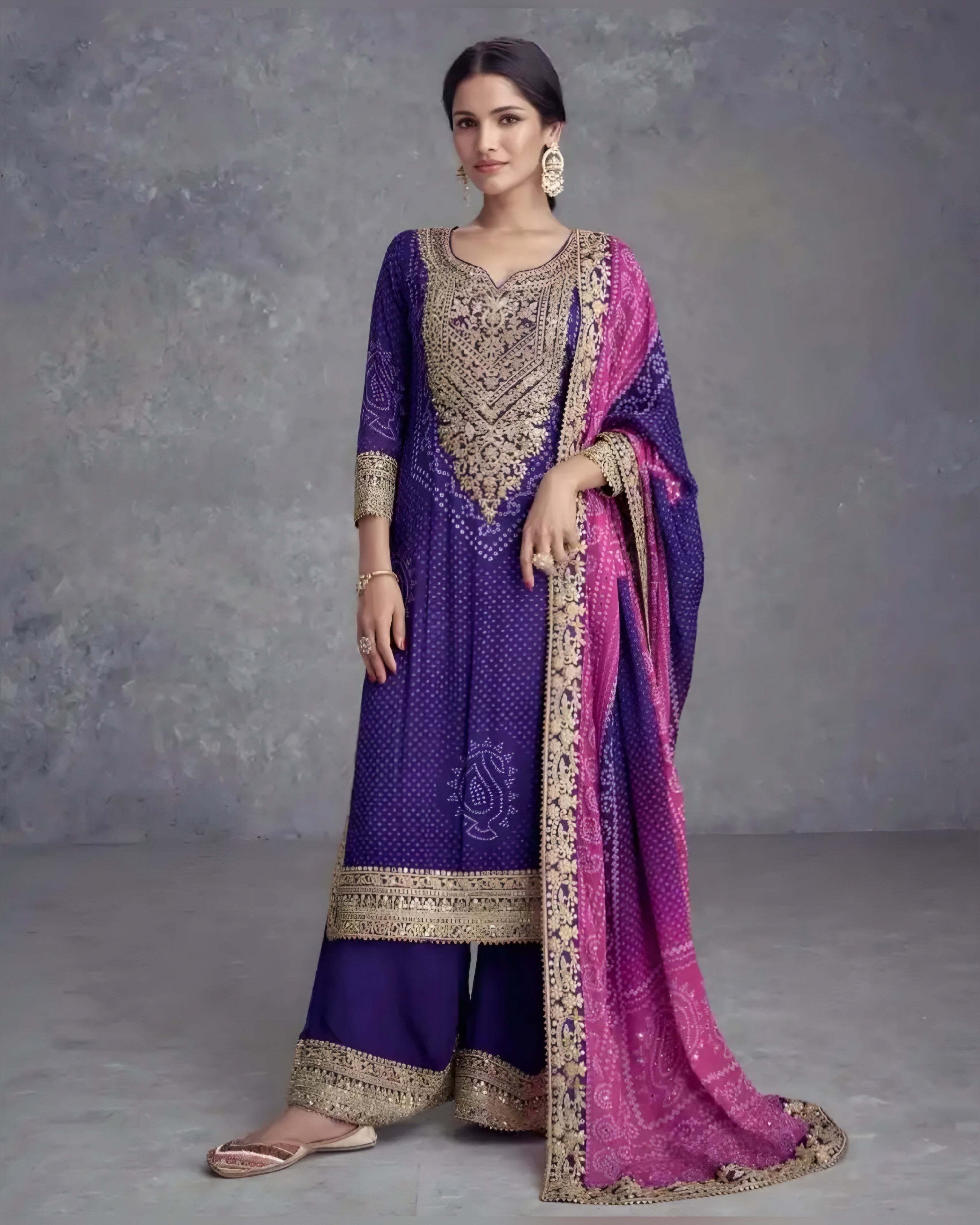 Woman wearing a traditional outfit with a purple and pink sari against a gray background