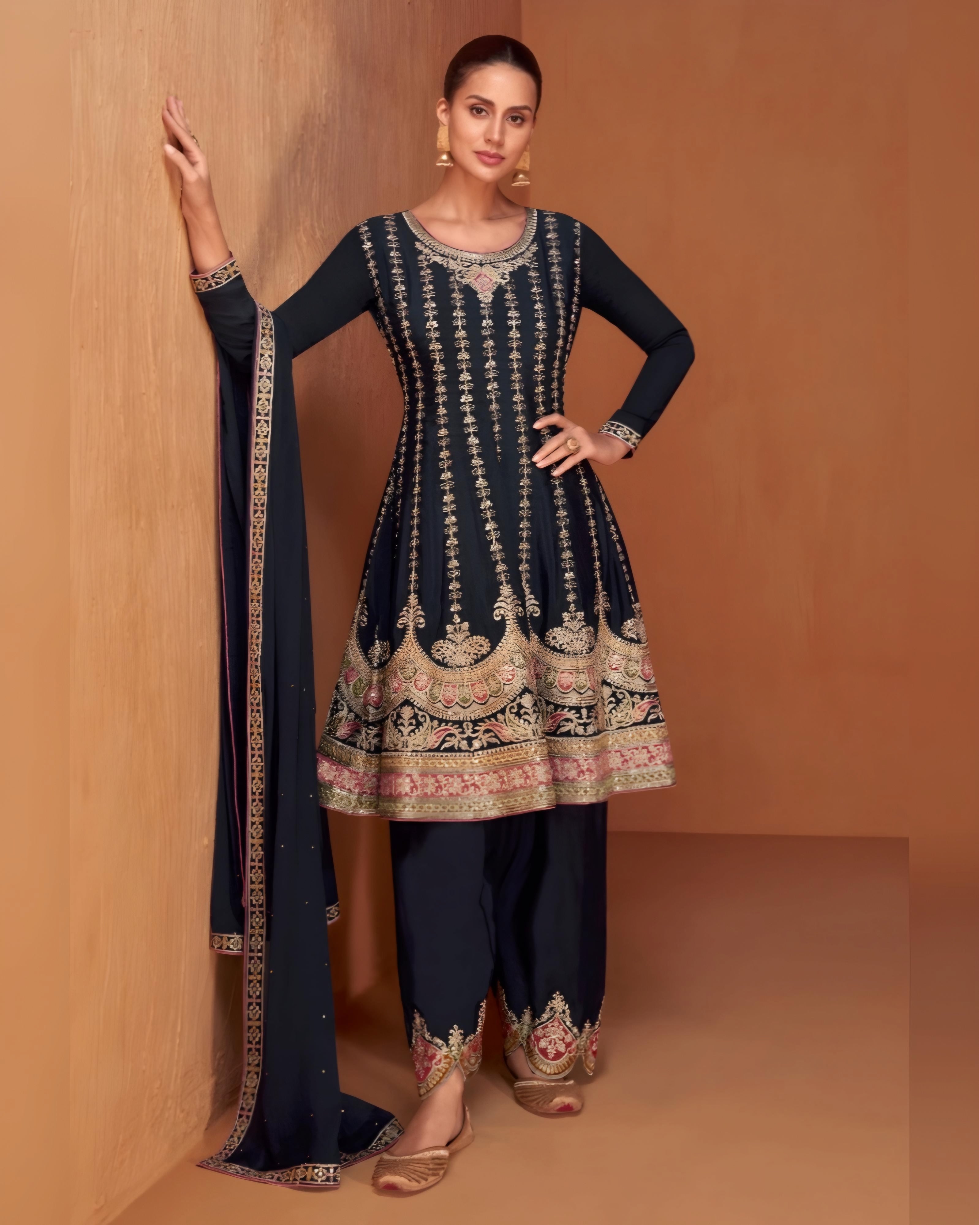 A woman wearing a navy blue palazzo suit with embroidered details and a dupatta.