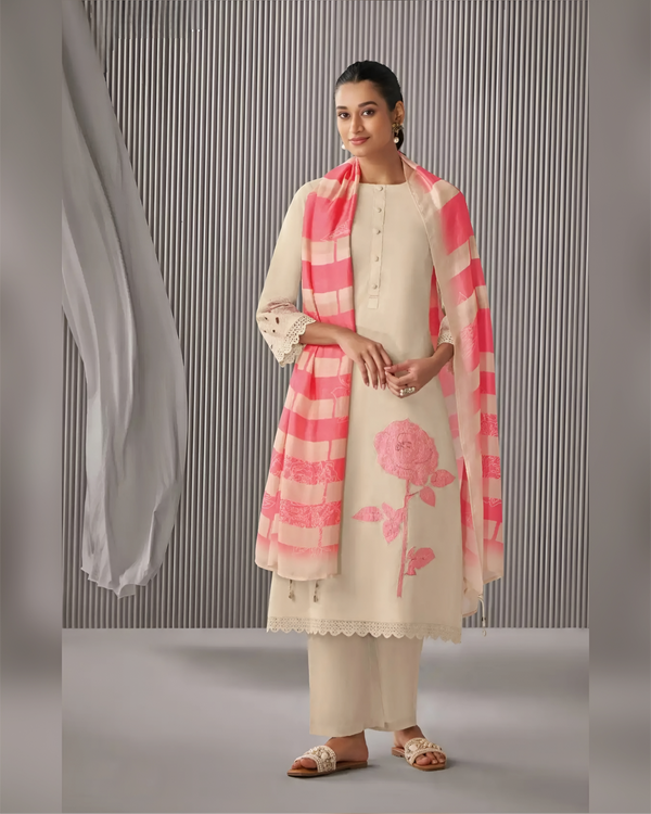 Woman wearing a cream kurta with pink floral design and matching dupatta against a gray background