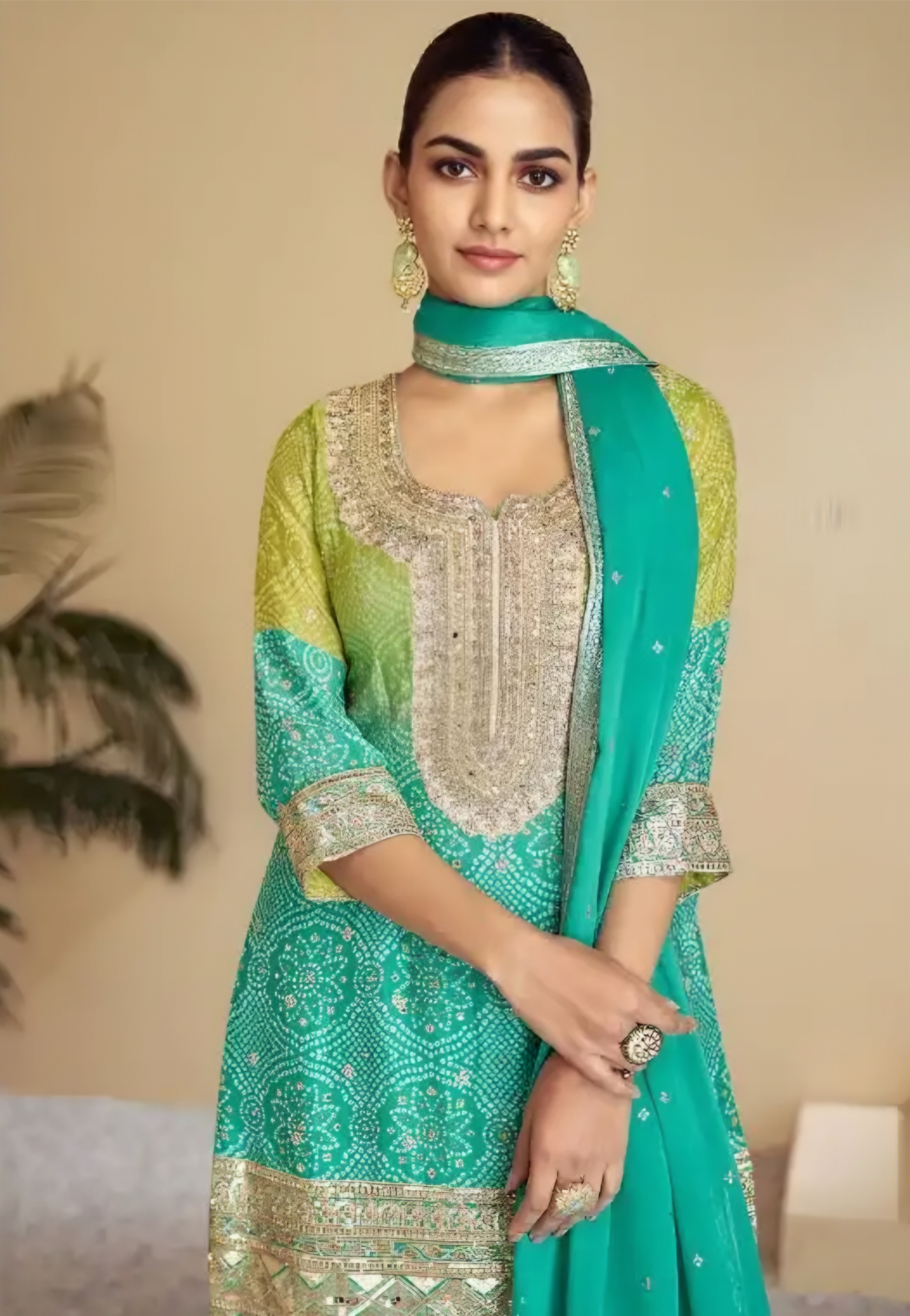Woman wearing a green and blue traditional outfit with a matching scarf against a beige background